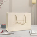 Luxury Ribbon Handle Cardboard Shopping Packaging Bag Customized Embossed Gold Foil Paper Gift Bags With Logo