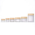 Wholesale Reusable Skincare Face & Eye Cream Jars Cylindrical Clear Frosted Glass Jar 30g 50g Screw Cap Plastic Wood Grain Lid