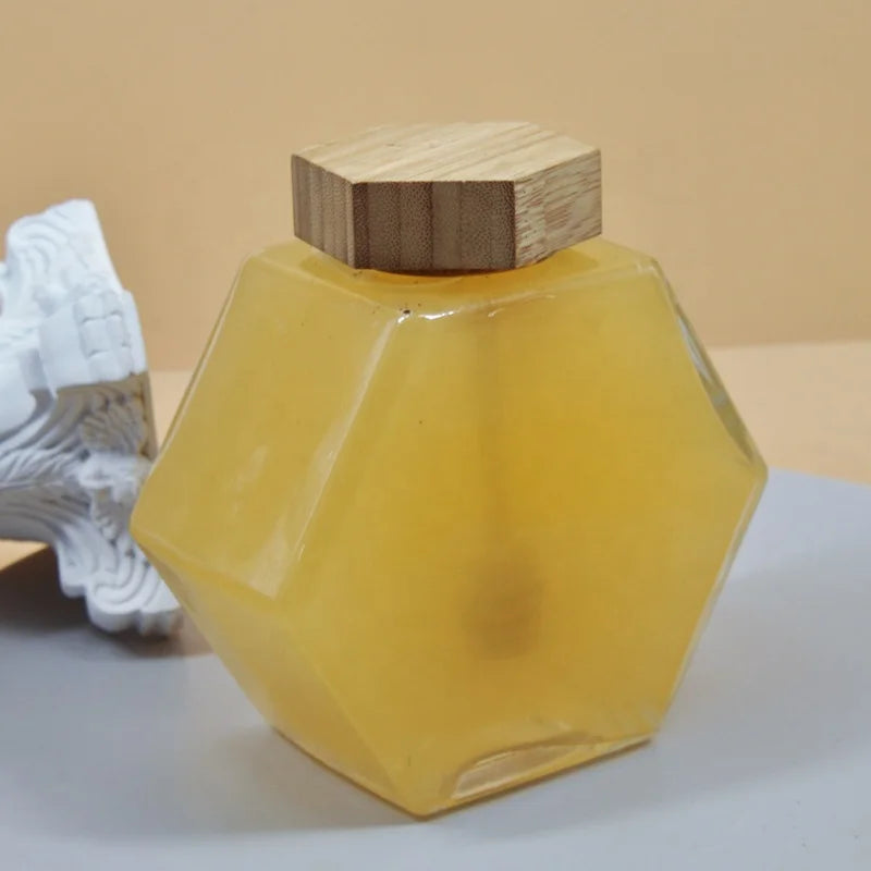Wholesale Hexagonal Glass Storage Honey Bottle with Wooden Dipper and Lid