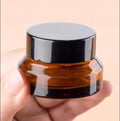 Wholesale 15g Amber Slanted Shoulder Eco-friendly Empty Glass Cream Cosmetic Jar with Customized Logo and Black Lid