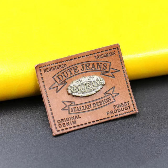 Hot Selling Custom Design Luxury Brand Trademark Eco-Friendly PU Material Garment Labels Custom Color Logo Debossed/Embossed