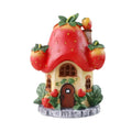 Solar-Powered Strawberry Fairy House Garden Light with Red Berry Roof and Green Leaves on a Beige Cottage