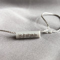 High Quality Nylon String Custom Design Brand Embossed logo Cylindrical 7*25mm Plastic Hang Tag String Label Seal Tag