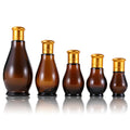 Wholesale 50ml & 100ml Gourd Shape Amber Glass Cosmetic Bottle with Gold Lid and Pump Sprayer for Lotion Storage