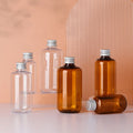 MGUP PACK 100ml 200ml 300ml Pet Transparent Brown Cosmetic Packaging Plastic Bottle With Aluminum Lid
