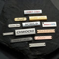 Wholesale Custom Metal Crafts Engraved Brand Logo with Metallic Tag Garment Bag Accessories for Swimsuits and Clothing