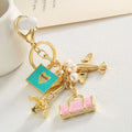 Wholesale Fashion Golden Travel Bag Airplane Eiffel Tower air Travel Keychain Pearl Bag Pendant Charms for Women Metal Key Chain